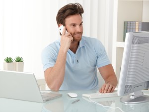 Office worker guy using computer and phone