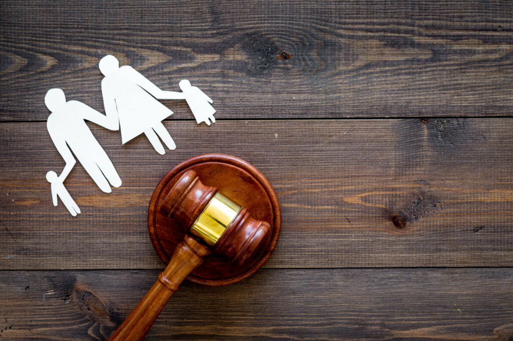 Famille avec enfants découpés près d'un marteau de tribunal sur fond de bois foncé, droit de la famille à Jacksonville, avocat spécialisé en droit de la famille.