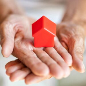 hands holding out red model house, international probate inheritance