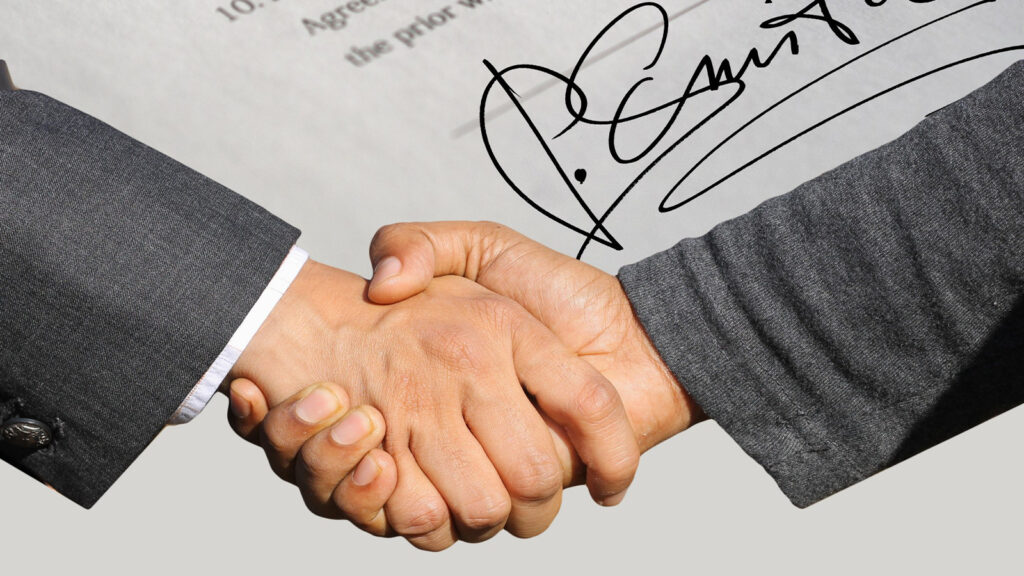 hommes d'affaires se serrant la main avec un contrat en arrière-plan, erreurs de contrat